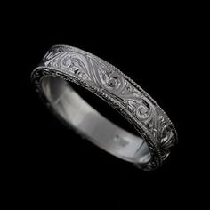 a wedding ring with intricate engraving on the side and an engraved pattern in the middle