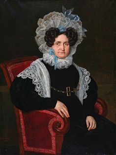 an old woman sitting in a red chair with a white ruffle on her head