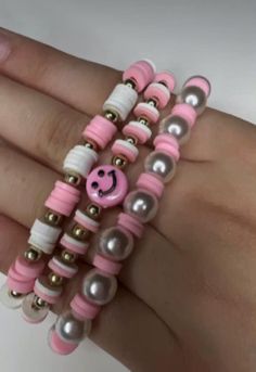 a woman's hand with pink and white bracelets