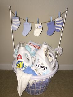 the laundry basket is filled with cleaning products and baby's socks hanging from clothes pins