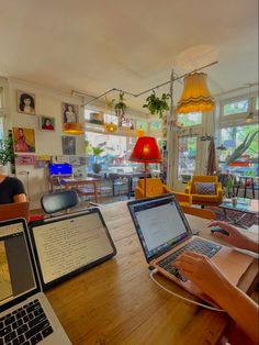 two people sitting at a table with laptops