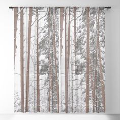 a window curtain with trees covered in snow