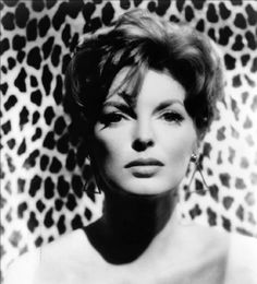 an old photo of a woman in front of a leopard print wall with her eyes closed