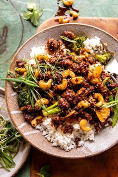 a bowl filled with rice, broccoli and cashews