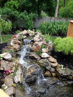 a small waterfall in the middle of a garden