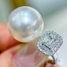 Highlights:  This luxurious ring features a 15.2mm South Sea Aurora Pearl, known for its baby-smooth nacre and exceptional luster, paired with a 0.6-carat E/VS1 diamond as the centerpiece. The combination of the pearl's delicate beauty and the brilliance of the diamond creates a stunning piece of jewelry, exuding elegance and sophistication. Perfect for those seeking a timeless, opulent statement. Product Information OriginSouth Sea Pearl Jewelry Processed in Japan MaterialSouth Sea Pearl, 18K Gold, and Natural Diamonds Dimensions-  Pearl Shaped: Round Size: 15-16 mm Quality: AAAA Nacre: Very Thick Color: White Luster: Aurora  Accessories Metal: 5.5 g of 18k White Gold Other: 0.60 ct of E/Vs1 + 0.30 ct of SI Quality Natural Diamonds Luxury White Pearl Open Ring, Luxury White Diamond Ring With Halo Design, White Luxury Halo Ring, Luxury Round Pearl Ring With Halo, Luxury Formal Pearl Ring With Halo, Luxury White Pearl Ring With Halo Setting, Luxury Round Cut Pearl Ring With Halo Setting, Luxury Pearl Ring With Halo Setting, Luxury Halo Setting Pearl Ring Gift