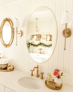 a bathroom with a sink, mirror and candles on the counter in front of it