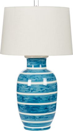 a blue and white striped lamp with a white shade on the top, sitting against a white background