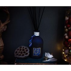 a blue bottle sitting on top of a table next to a vase filled with ornaments