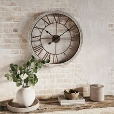 a clock on the wall above a vase with a plant in it and other items