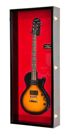 an electric guitar in a case with red and yellow background on the wall, it's hard to tell what kind of instrument this is