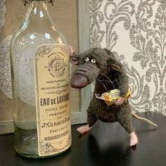 a stuffed rat is next to a bottle