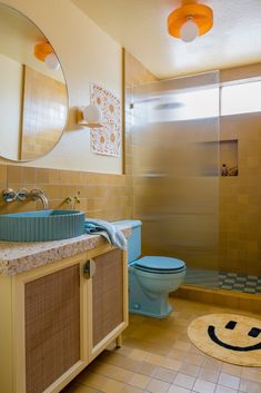 a bathroom with a blue toilet sitting next to a walk in shower and a sink