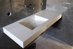 a white sink sitting under a mirror next to a wall mounted faucet in a bathroom