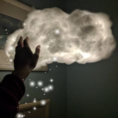 a hand reaching up to a cloud in the air