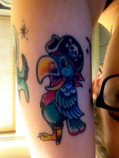 a person with a tattoo on their arm and the image of a toucan