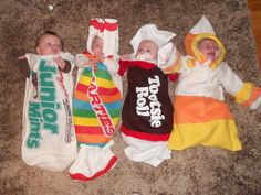 three babies are laying on the floor wearing costumes