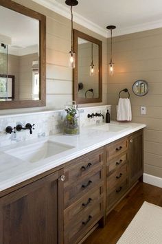 a bathroom with two sinks and mirrors on the wall