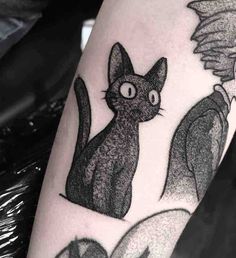 a black and white cat tattoo on the leg