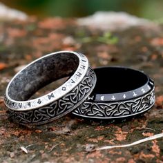 two black rings with silver lettering on them are sitting on the ground next to each other