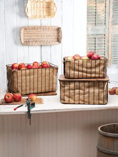 three baskets filled with apples sitting on top of a window sill next to a barrel