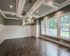 an empty room with wood floors and chandelier