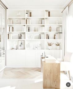 a white room with bookshelves and chairs