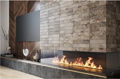 a modern fireplace in a living room next to a wall mounted tv and vases