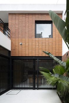 the entrance to an apartment building with wooden panels on the wall and black iron gates