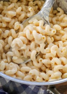 macaroni and cheese being stirred with a ladle