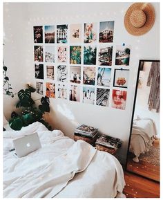 a bedroom with pictures on the wall and a laptop computer sitting on top of it