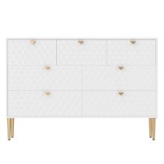 a white dresser with gold handles and geometric designs on the front, along with two brass legs