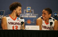 two men sitting at a table with microphones in front of them