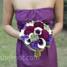 a woman in a purple dress holding a bouquet of flowers