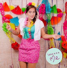 a woman standing in front of a wall with colorful paper decorations on it's sides