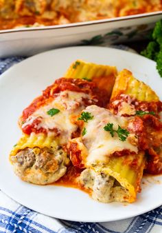 a white plate topped with lasagna shells covered in sauce and parmesan cheese