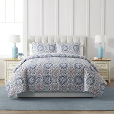 a bed with blue and white bedspread in a room