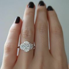 a woman's hand with a diamond ring on it