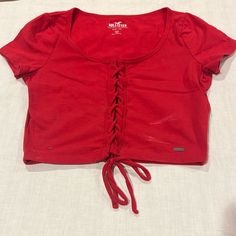 Hollister Must Have Collection Baby Tee Red Cotton Cinch Down Center Small -Size Women’s Small -Super Soft & Versatile Baby Tee With Adorable Braiding Cinched Down The Center -Great Preloved Condition, Some Deodorant Marks That Can Be Removed But Otherwise Basically Brand New With Lots Of Life Left :) -Material: Cotton -Measurements: Pit To Pit 14”, Shoulder To Hem 15” Dispatch In 1-2 Business Days Send Me An Offer! See My Shop Policies & Faqs For More No Trades & Everything Is Final Sale. I Am Casual Drawstring Crop Top, Trendy Crop Top With Drawstring, Trendy Drawstring Crop Top, Red Short Sleeve Casual Crop Top, Casual Red Short Sleeve Crop Top, Trendy Cotton Crop Top With Drawstring, Red Casual Crop Top, Fitted Short Sleeve Tops With Drawstring, Red Cotton Crop Top