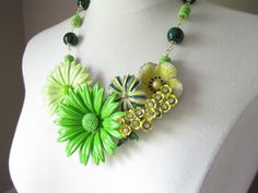 This entire necklace was designed around the spray of tiny yellow enamel flowers that have rhinestone centers and green leaves.  Previously a vintage brooch, I combined it with four other vintage enamel flower brooches in complementary shades of lemon yellow, lime green, and grass green (all backs removed).  This beautiful bouquet is securely mounted upon a clear lucite necklace base and measures approximately 6 inches across by 4 inches top to bottom (at its widest and tallest points).   I've a Green Enamel Jewelry For Wedding, Green Flower Pendant Jewelry For Wedding, Green Enamel Wedding Jewelry, Green Flower-shaped Enamel Jewelry, Green Flower Pendant Necklace For Wedding, Green Gardens, Enamel Flowers, Blue Words, Yellow Lime