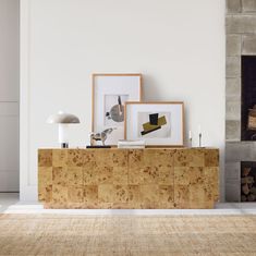 a living room with white walls and wooden furniture in front of a fire place on the wall