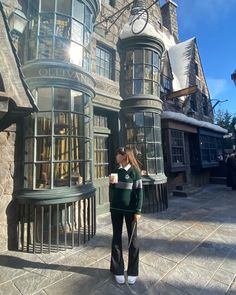 a woman standing in front of a hog potter's house