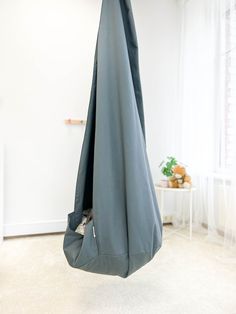 a blue blanket hanging from the ceiling in a room with white walls and carpeted flooring