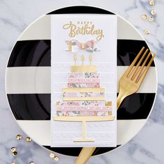 a black and white plate topped with a birthday card next to a gold fork on top of it