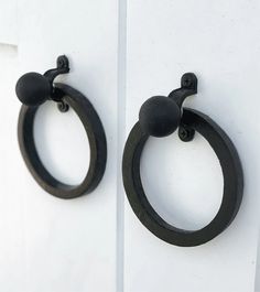 two black rings hang on the side of a white door