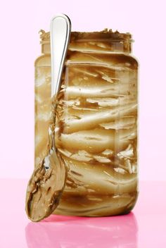 a jar filled with peanut butter and a spoon