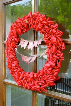 a red wreath is hanging on the front door