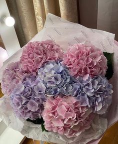 a bouquet of pink and purple flowers sitting on top of a table