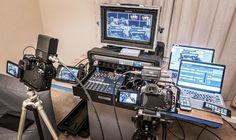 there are three cameras and two laptops on the table with other equipment in front of them