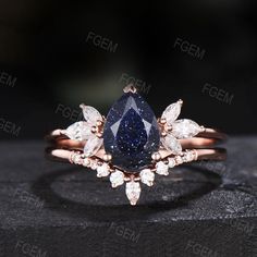 a blue diamond ring with white diamonds on it's sides and the center stone is surrounded